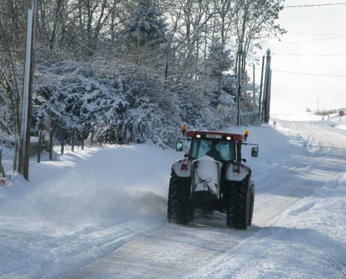 contrat de déneigement : le tracteur avec sa lame à neige et son bac à saler
